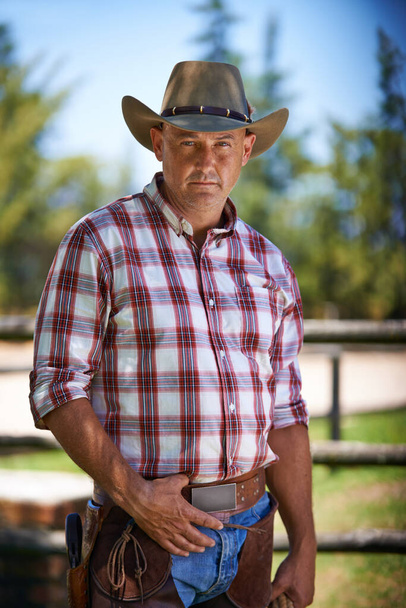 Er ist der Zänker der Biester. Ein reifer Cowboy draußen auf seinem Bauernhof - Foto, Bild