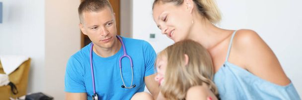 Doctor conducts medical examination of child with mother in hotel room. Medical insurance and assistance for tourists concept - Foto, imagen