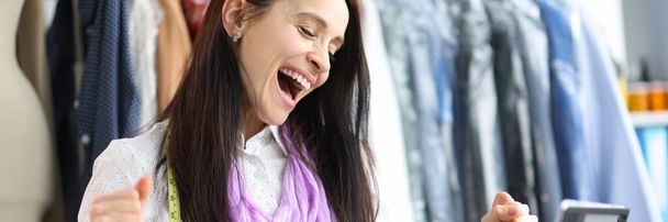 Joyful happy woman seamstress stylist at workplace. Successful fashion collection concept - Foto, Bild