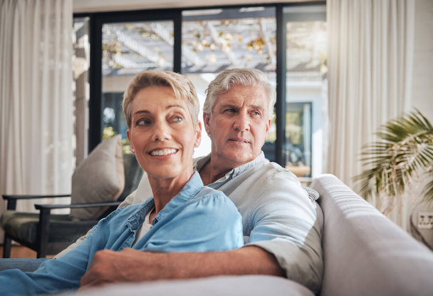 Thinking, future and senior couple sitting on the sofa at home dreaming about a carefree retirement together to relax and find peace. Mature man and woman looking away enjoying wellbeing and love. - 写真・画像