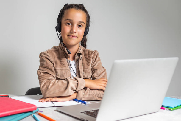 Mosolygó kis kaukázusi lány fülhallgató kézírás tanulmány online laptoppal otthon, aranyos boldog kis gyermek fülhallgató venni internetes webes lecke vagy osztály a számítógépen, magántanuló koncepció. - Fotó, kép