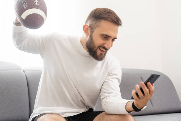 happy businessman with rugby ball and smartphone. - Zdjęcie, obraz