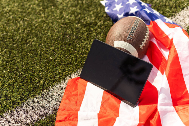 american football ball and tablet, american flag. - Foto, imagen