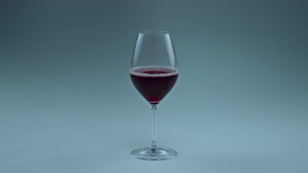 Closeup red wine drop falling glass. Spirituous liquid filling vessel in super slow motion. Inebriant rose tipple splashing in goblet. Intoxicant merlot inside clean container. Degustation concept - Footage, Video