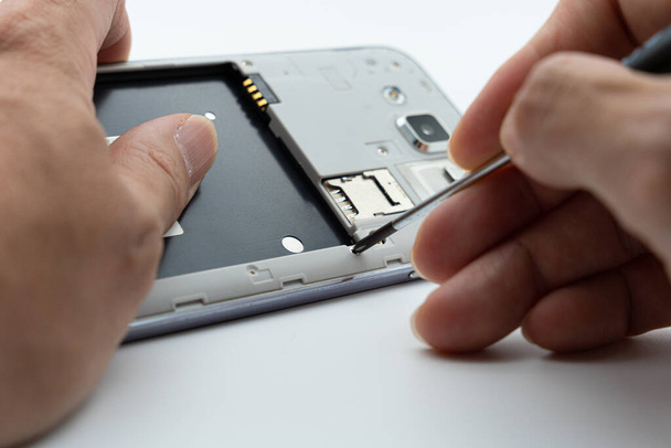 La situation de la réparation d'un téléphone portable à l'aide d'un outil de tournevis - Photo, image
