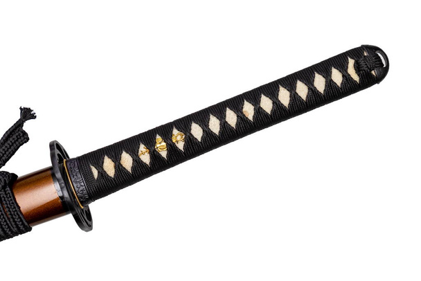 Tsuka - mango de espada japonesa envuelto por cordón de seda negro sobre piel de rayo blanco aislado en fondo blanco. Enfoque selectivo. - Foto, Imagen