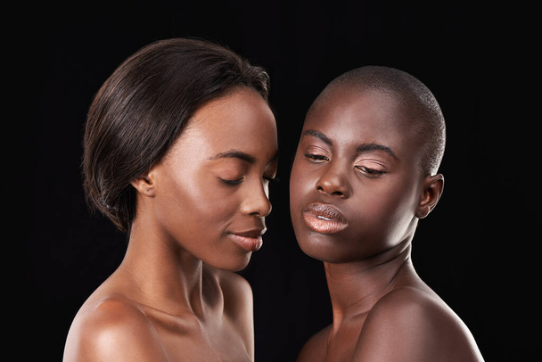Ware Afrikaanse schoonheid. twee mooie afrikaanse vrouwen staan samen tegen een zwarte achtergrond - Foto, afbeelding