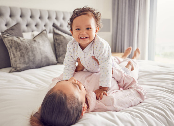 Baby, family and love with a mother and her girl bonding on bed in the bedroom of their home together. Children, parent and daughter with a single mom and her cute daughter in a house with a smile. - Photo, Image