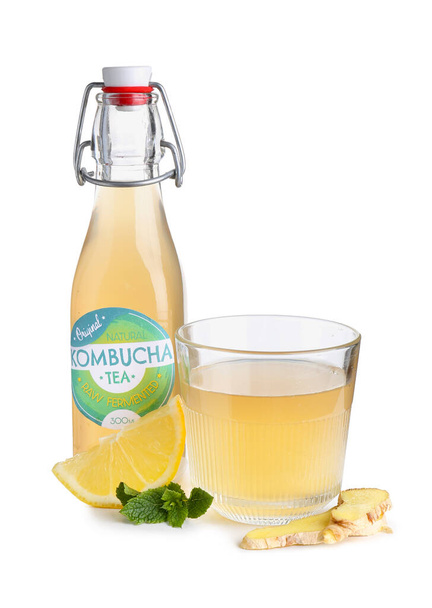 Fles van natuurlijke kombucha thee met gember en citroen op witte achtergrond - Foto, afbeelding