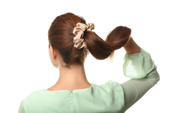 Woman with ponytail and silk scrunchy on white background - Foto, Bild