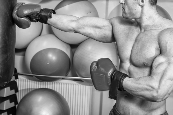 Мужчина ударил боксерскую грушу в спортзале
 - Фото, изображение