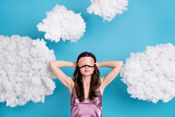 Portrait of attractive girl relaxing sleeping fluffy clouds flying isolated over bright blue color background. - 写真・画像