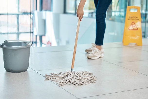 Woman cleaner mop floor at office, with water in plastic bucket and put sign as warning or caution for staff. Employee janitor clean building put danger signal, as service to company or business - Foto, immagini