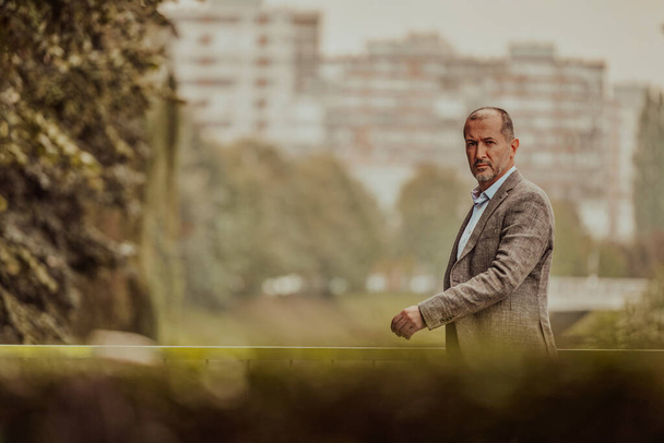 Focused businessman in a suit walking in the park. High quality photo - Zdjęcie, obraz