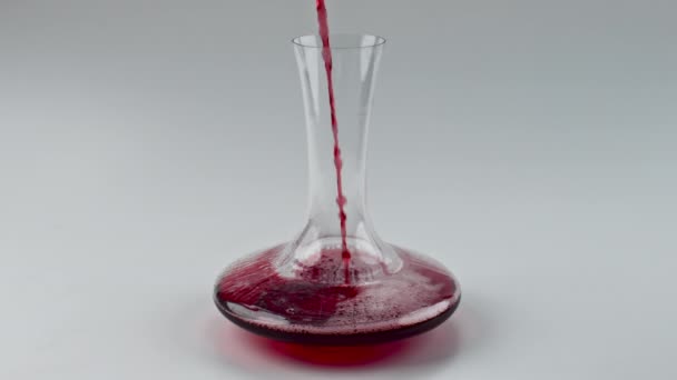 Closeup gieten rode wijn glazen kom binnen. Alcoholische vloeibare vulling decanter super slow motion. Onhandige roos spetterend transparant glaswerk macro. Merlot golf in schone zuivere container - Video