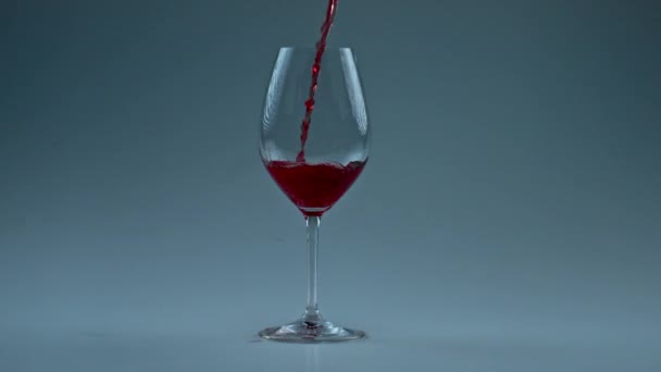 Sprankelende wijn jet gieten glas close-up. Fizzy alcohol vloeistof vullen schone vat slow motion. Verfrissende rode drank spetterend in wijnglas witte achtergrond. Luxe elegantie tipple concept  - Video