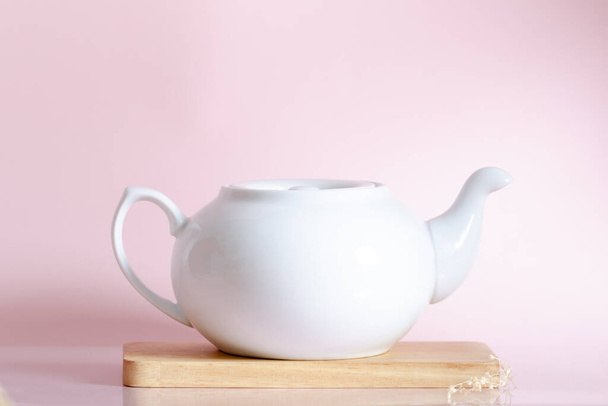 White teapot on pink background. - Zdjęcie, obraz