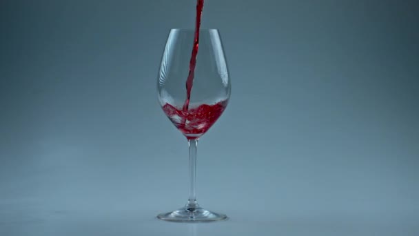Intoxicant drank vullen beker slow motion. Giet alcoholische vloeistof schoon wijnglas witte achtergrond. Rode wijn vormt prachtige golf in glas. Rose jet streaming transparante containerwand  - Video