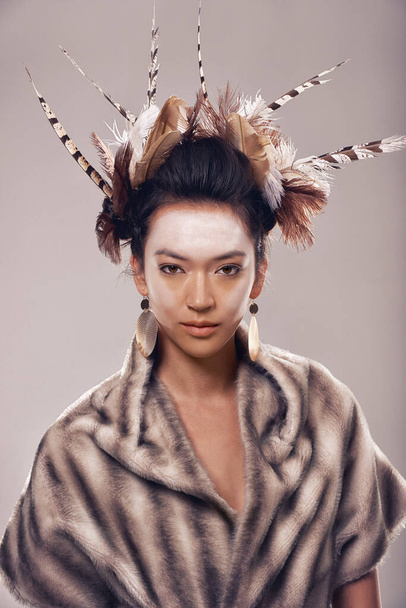 Adorned in tradition. Studio portrait of a young woman in a fur shawl and native american-inspired clothing - Foto, Imagem