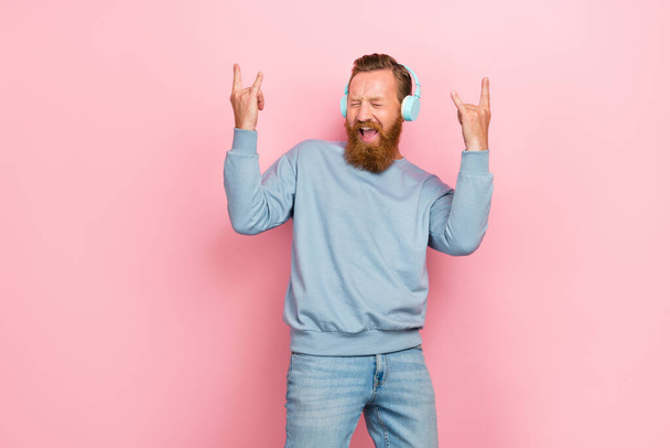 Photo of careless childish person listen song fingers demonstrate heavy metal symbol isolated on pink color background. - Foto, Imagem