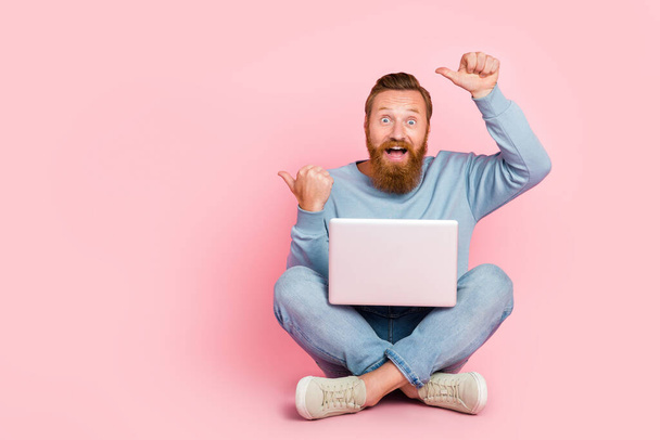 Full body portrait of astonished cheerful handsome guy indicate thumb fingers empty space isolated on pink color background. - Фото, зображення