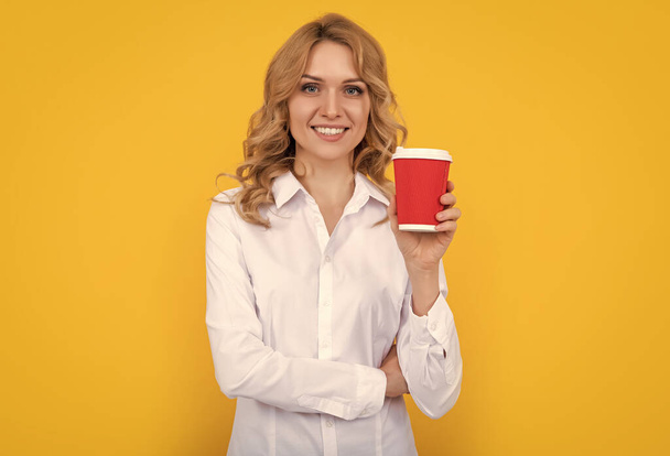 笑顔ブロンド女性とともにコーヒーカップ上の黄色の背景. - 写真・画像