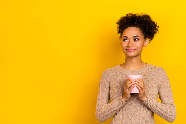 Photo of pretty thoughtful woman wear beige sweater drinking tasty tea empty space isolated yellow color background. - Zdjęcie, obraz