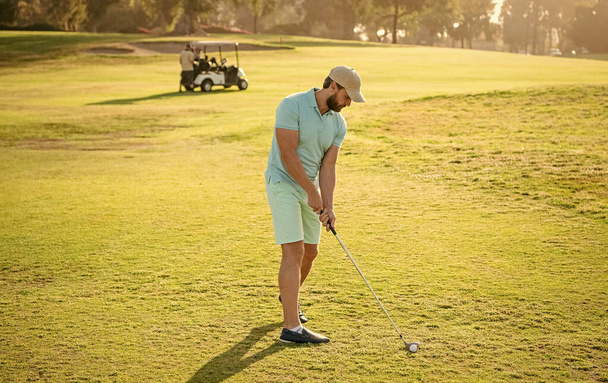 стоя гольфиста в кепке с клюшкой для гольфа, гольф качели. - Фото, изображение