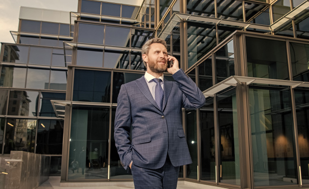 successful entrepreneur in businesslike suit has phone conversation outside the office, conversation. - Photo, Image