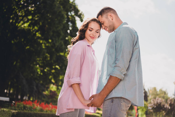 Profile photo of two peaceful idyllic young people hold hands closed eyes enjoy warm weather date outdoors. - Foto, Imagem