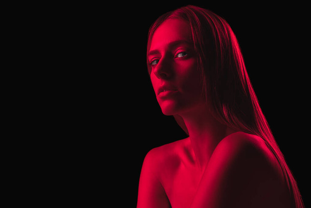 Spooky dark red night. Young sensual woman in neon light on dark background. Cyberpunk style, beauty, halloween concept. Beautiful, mysterious, mystical model. Glow - Photo, image