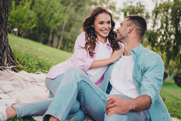 Photo of dreamy adorable two people together wear casual shirts smiling sitting blanket under tree outside garden. - Foto, immagini