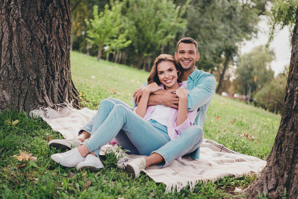 Photo of dreamy sweet boyfriend girlfriend wear casual outfits sitting grass hugging enjoying sunny weather outdoors garden. - Foto, immagini