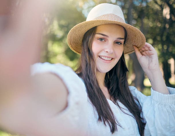 Selfie portret van de vrouw in het natuurpark ontspannen, gelukkig en glimlachen terwijl in het buitenbos voor rust, stilte en vrijheid. Geluk, bomen en kalme meisje op de foto om te posten op online social media app. - Foto, afbeelding