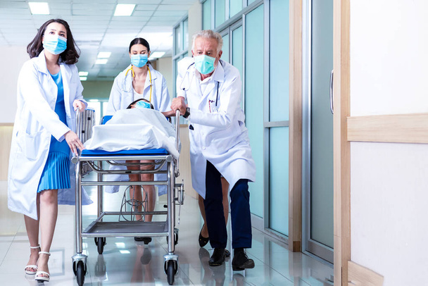 Selecciona foco. Equipo médico empujando camilla camilla camilla corredor con paciente femenino en el hospital. Concepto de atención médica - Foto, Imagen
