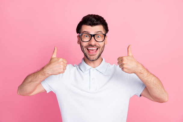 Closeup photo of young funny excited positive man wear white t-shirt polo fingers thumbs up toothy smile recommend new product isolated on pink color background. - Фото, изображение