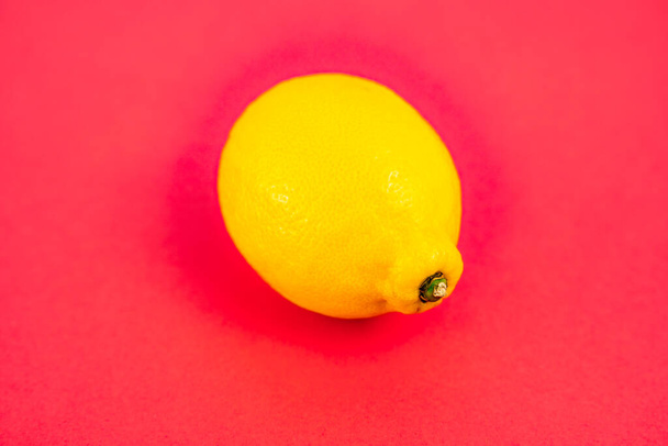 Ausgewählte Zitrone auf rotem Hintergrund. 3 / 4 Ansicht - Foto, Bild