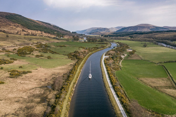 A Yacht Motoring Through a River Surrounded By Beautiful Landscape - Foto, Imagem