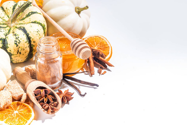 Autumn fall pumpkin spice baking and drink ingredients. Various colorful pumpkins, nuts, seasonal spices on white background. Cooking pumpkin pie, latte, cookies for autumn Thanksgiving  holidays - Photo, image