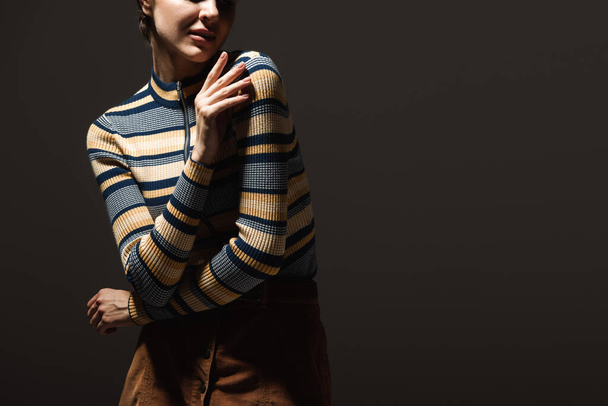 cropped view of young woman in stylish autumnal outfit posing on black  - Foto, Imagem