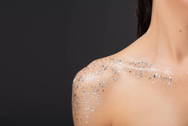 cropped view of young woman with sparkling glitter on clavicle and bare shoulder isolated on grey  - Fotoğraf, Görsel