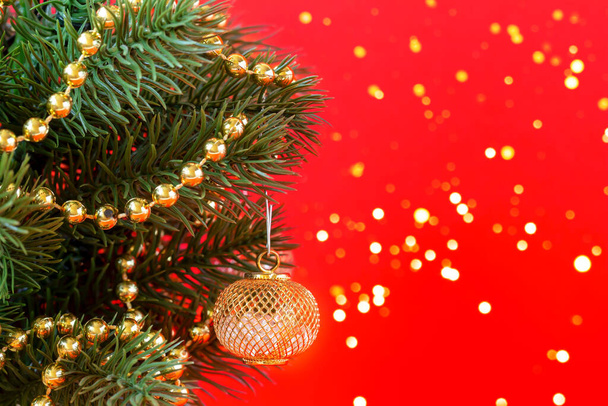 Sztuczna choinka w girlandach i dekoracje w garnku na czerwonym tle ze światłami. Nowy Rok i Boże Narodzenie tło z miejsca do kopiowania - Zdjęcie, obraz