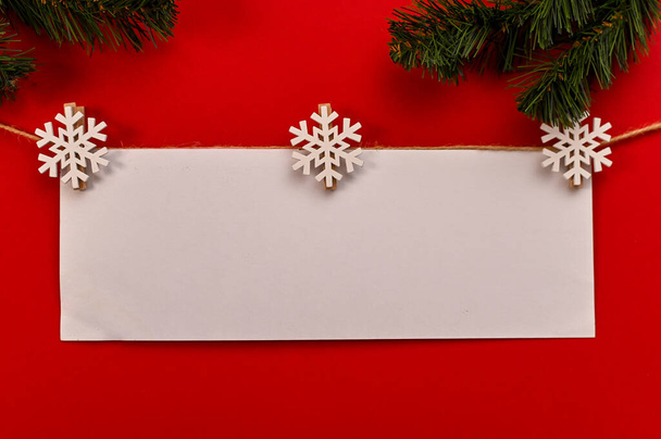 Karácsonyi újévi kompozíció. Egy üres papír elrendezés piros háttérrel. Lapos elrendezés, felülnézet, másolás, minimalizmus - Fotó, kép