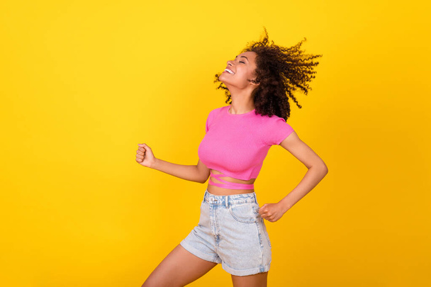 Photo of excited pretty girl closed eyes chilling dancing have good mood isolated on yellow color background. - Foto, Imagem