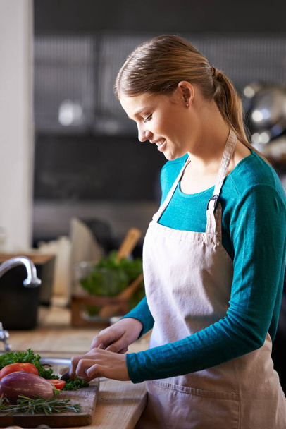 Szczęśliwie odrąbuję. atrakcyjna młoda kobieta siekająca warzywa w kuchni - Zdjęcie, obraz