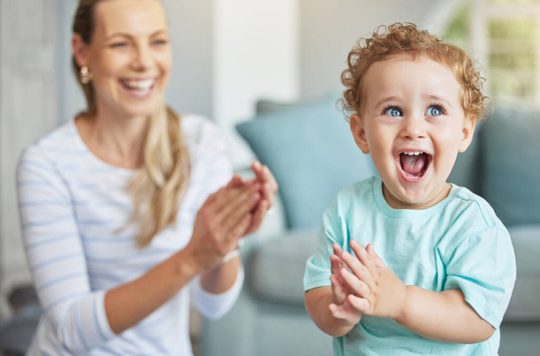 Happy, clapping hands and mother and son playing in the living room of their family home. Happiness, love and energy of parent and toddler having fun and cheering together in the lounge of a house - Fotografie, Obrázek
