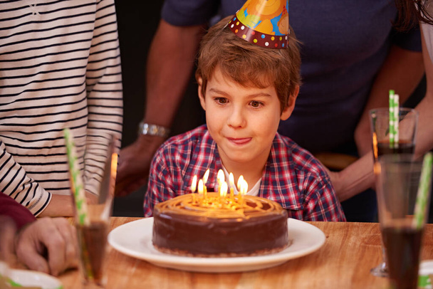 Quelqu'un a dit gâteau ? un jeune garçon se préparant à souffler les bougies sur son gâteau d'anniversaire - Photo, image