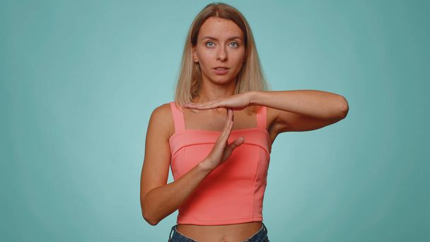 Tired serious upset woman 20 years old showing time out gesture, limit, stop break sign, no pressure, I need more time. Young adult slim thin slender girl isolated alone on blue studio wall background - Photo, Image