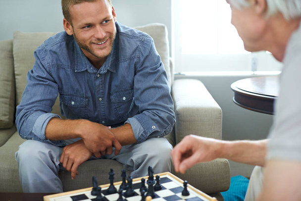 Ты действительно хорош в шахматах, пап. отец и сын играют в шахматы вместе дома - Фото, изображение