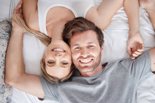 Couple portrait, above bed and smile for love marriage in bedroom, happy with support and content with sleep. Top view face of calm man and woman in happiness together after sleeping in apartment. - Fotó, kép